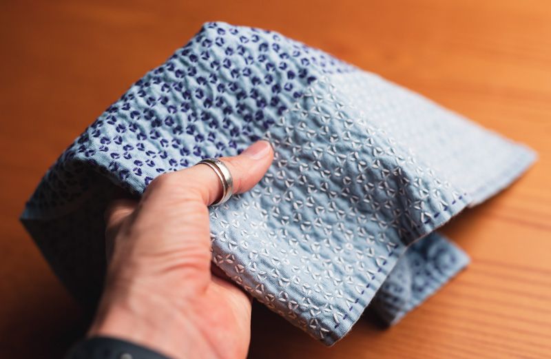 Sashiko cloth in blue with white and purple thread with a couple of imperfections