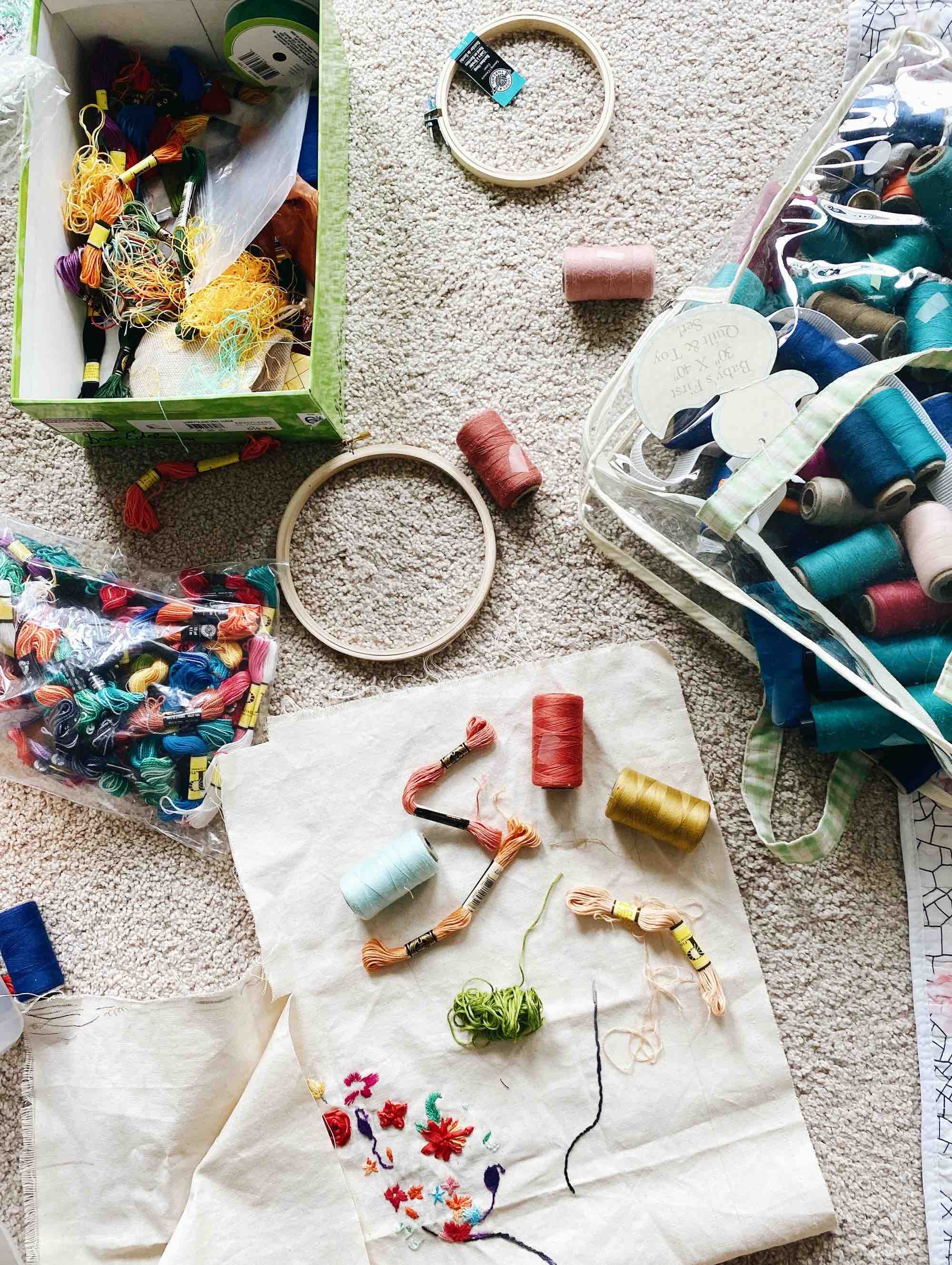 Various embroidery tools scattered on a carpet