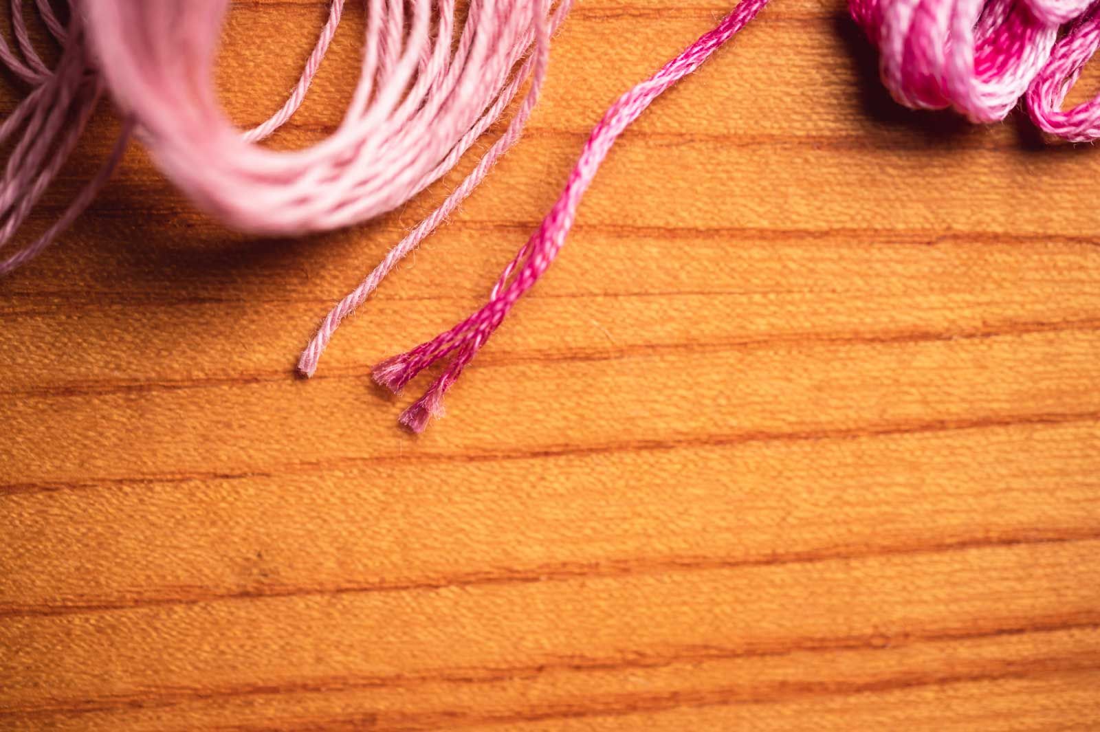 Pink sashiko thread on the left, pink embroidery thread on the right, cut ends looking different