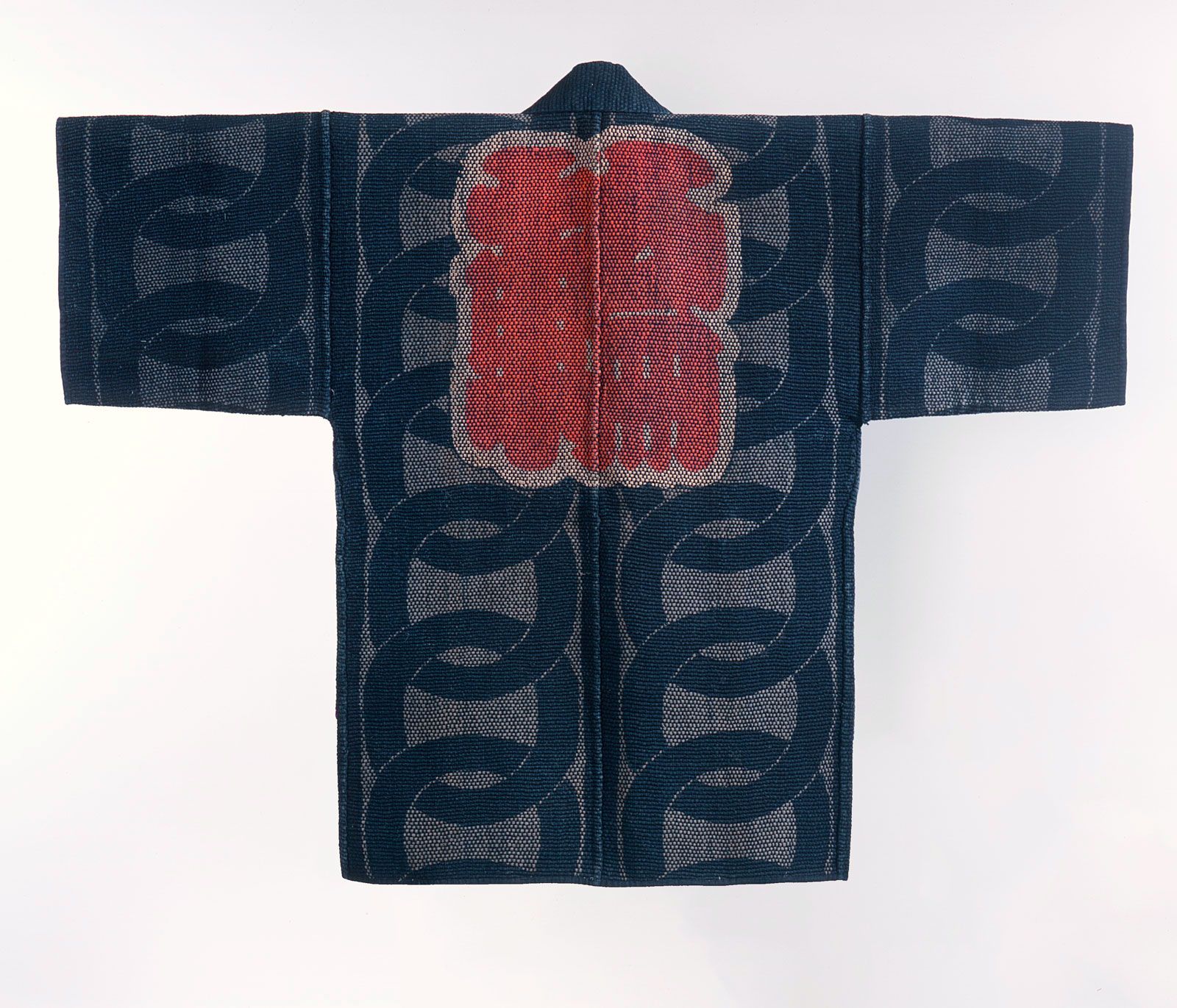 A hikeshi banten made of indigo cloth with sashiko stitches in white and a kanji stitched in red