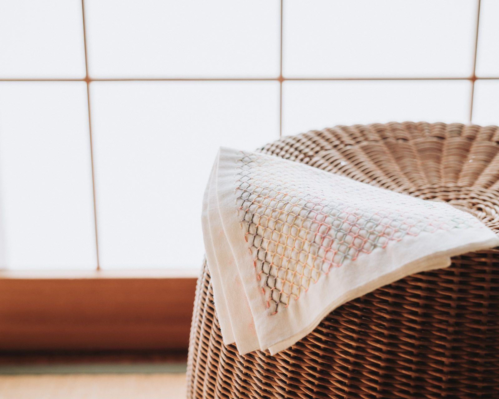 Sashiko cloth on a rattan chair in front of Japanese paper doors