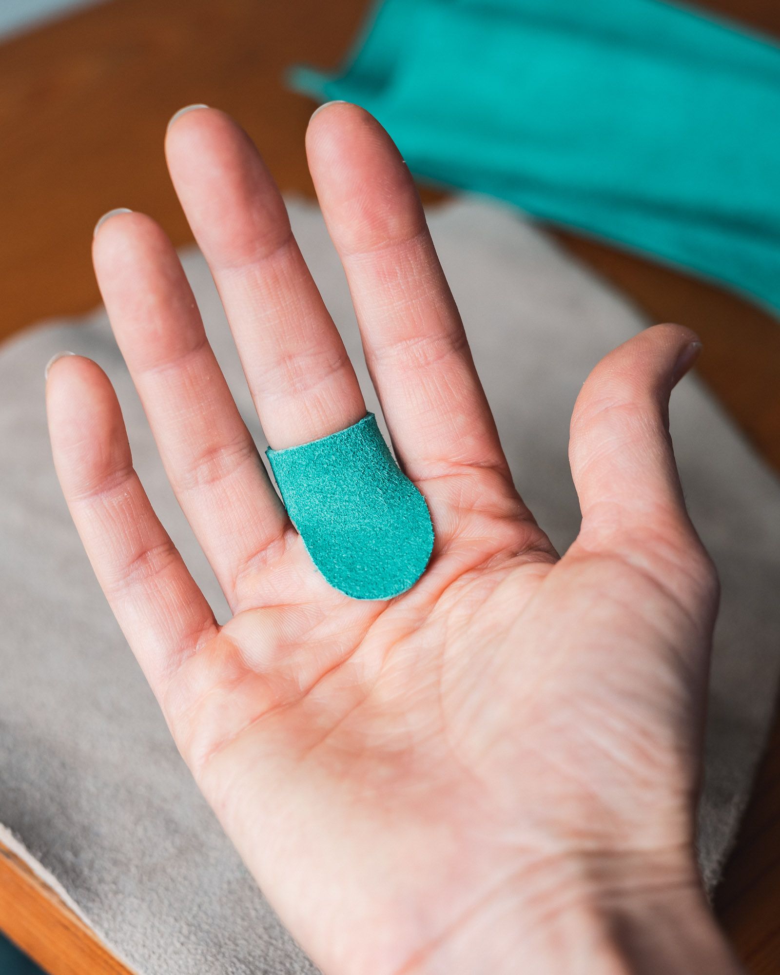 A green handmade leather thimble for sashiko