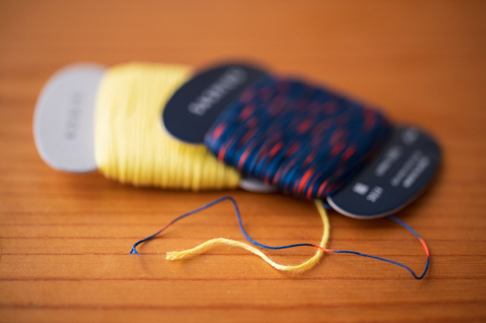 Yellow kogin thread and variegated blue and red sashiko thread close up for comparison.