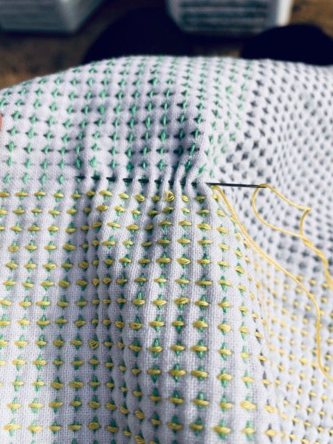 Sashiko pattern that looks like many plus signs lined up in green, gray and yellow.