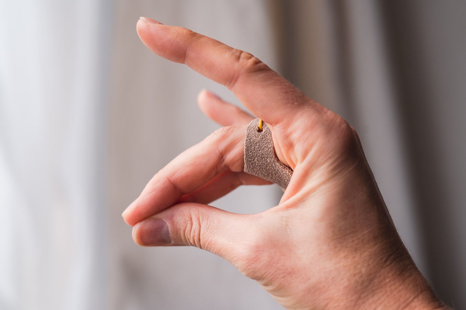 Fingers forming a fox with a palm thimble visible on the middle finger.