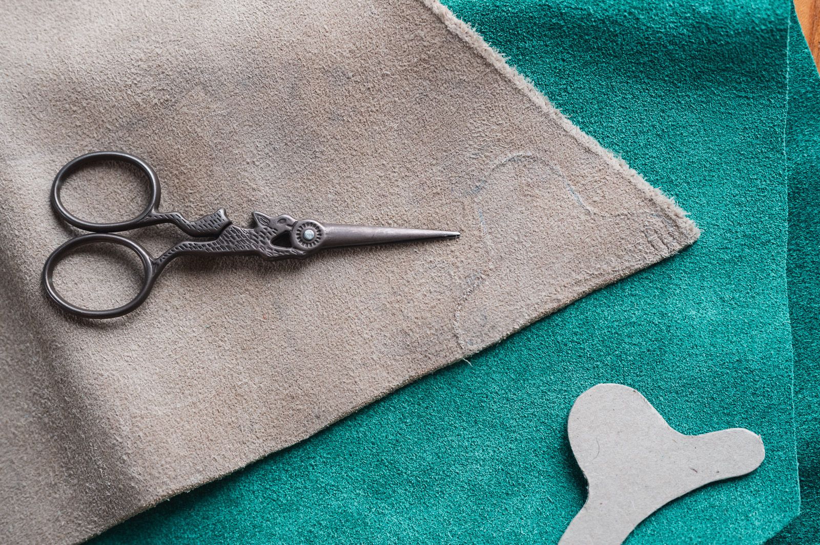 Scissors and scraps of leather with a template for a sashiko thimble visible.