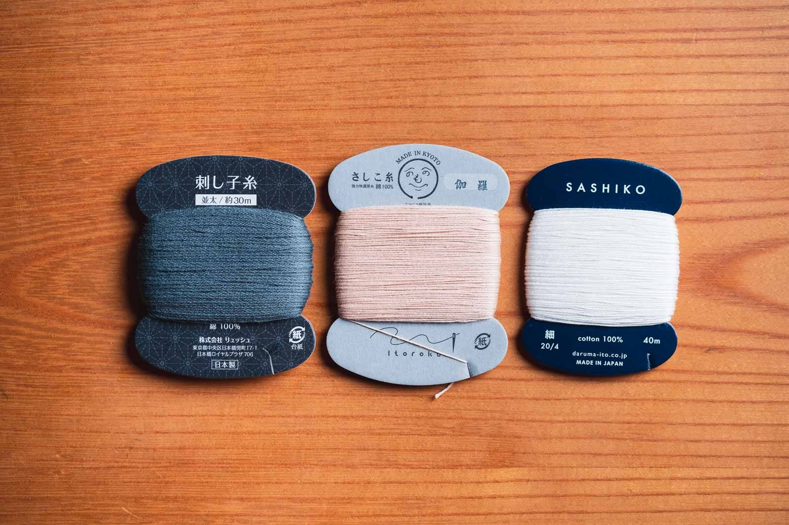 Three different sashiko thread brands on cards in different colors.