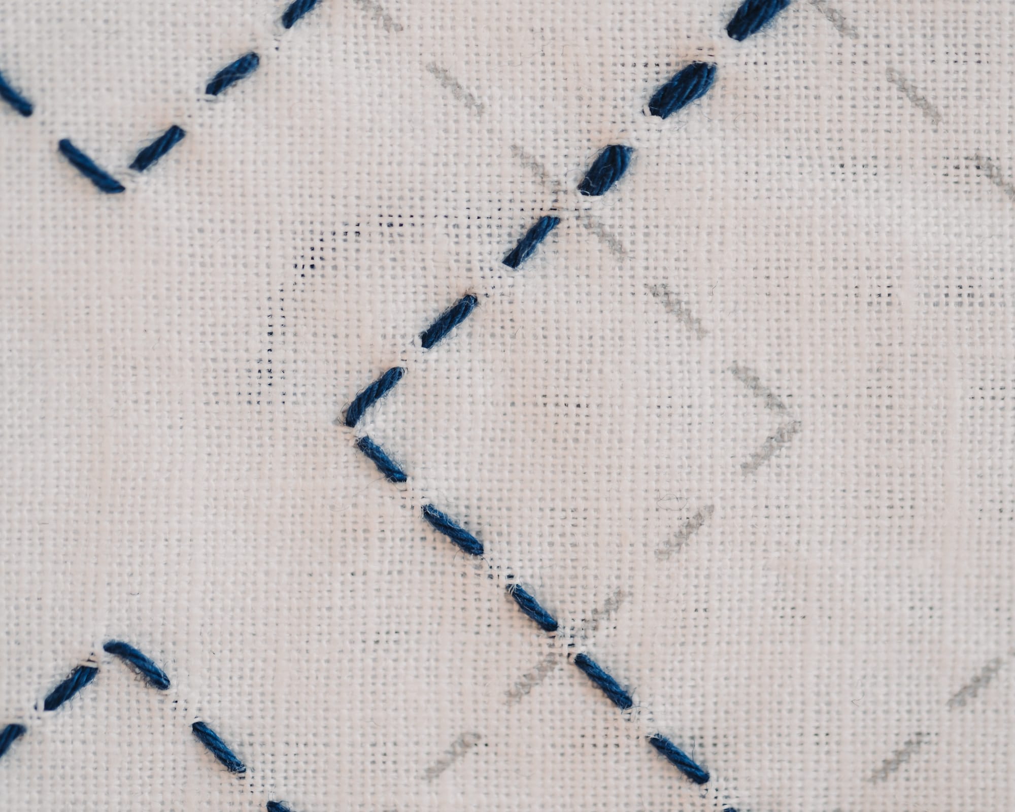 Pre-printed fabric with the kasanemasusashi sashiko pattern with some stitches not filled in on white fabric