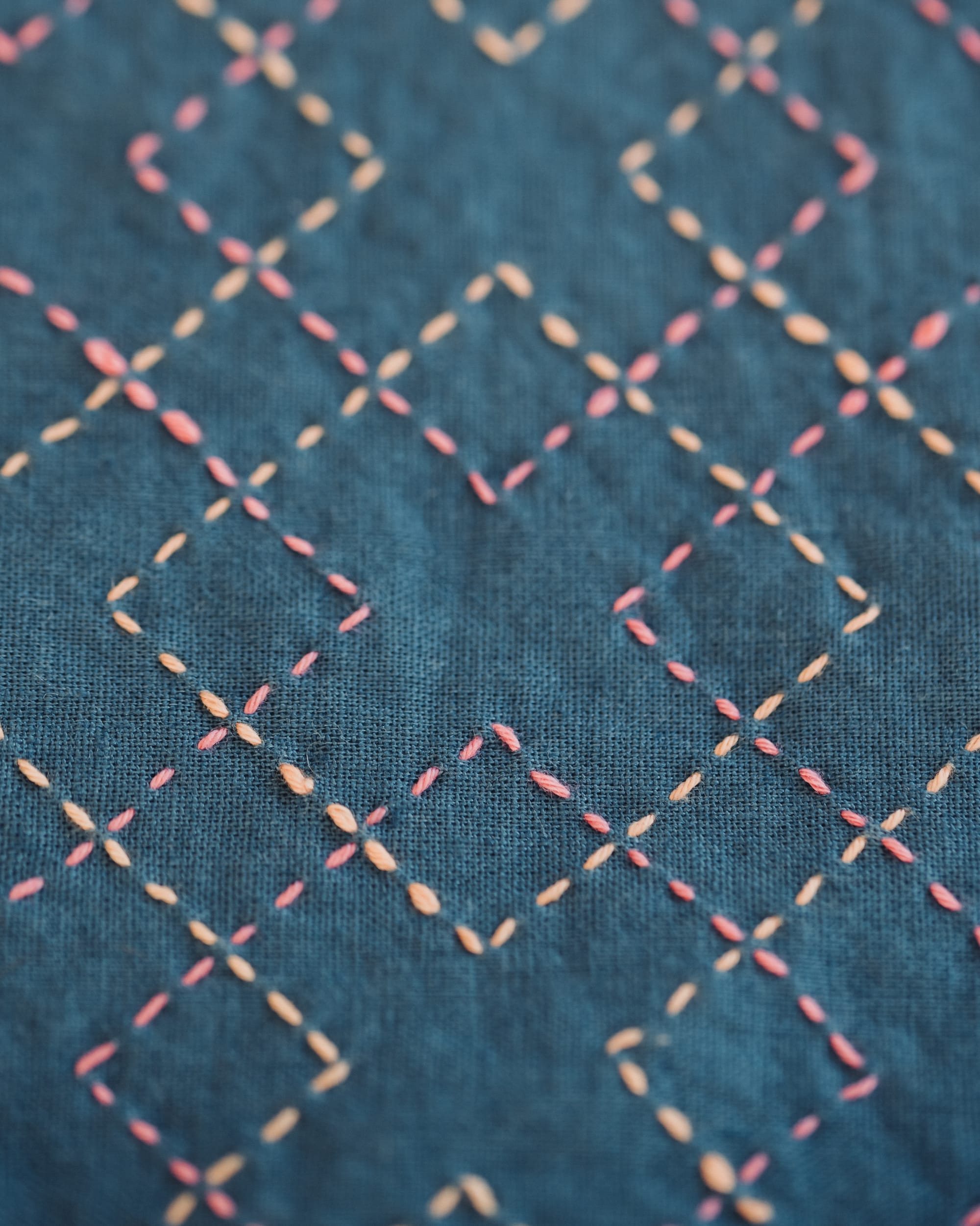 The sashiko pattern kasanemasusashi in yellow and pink on teal fabric