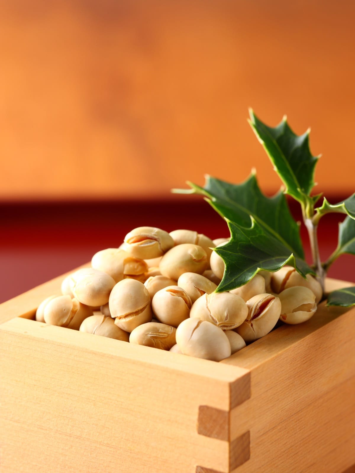 A wooden measuring cup with dried soy beans inside