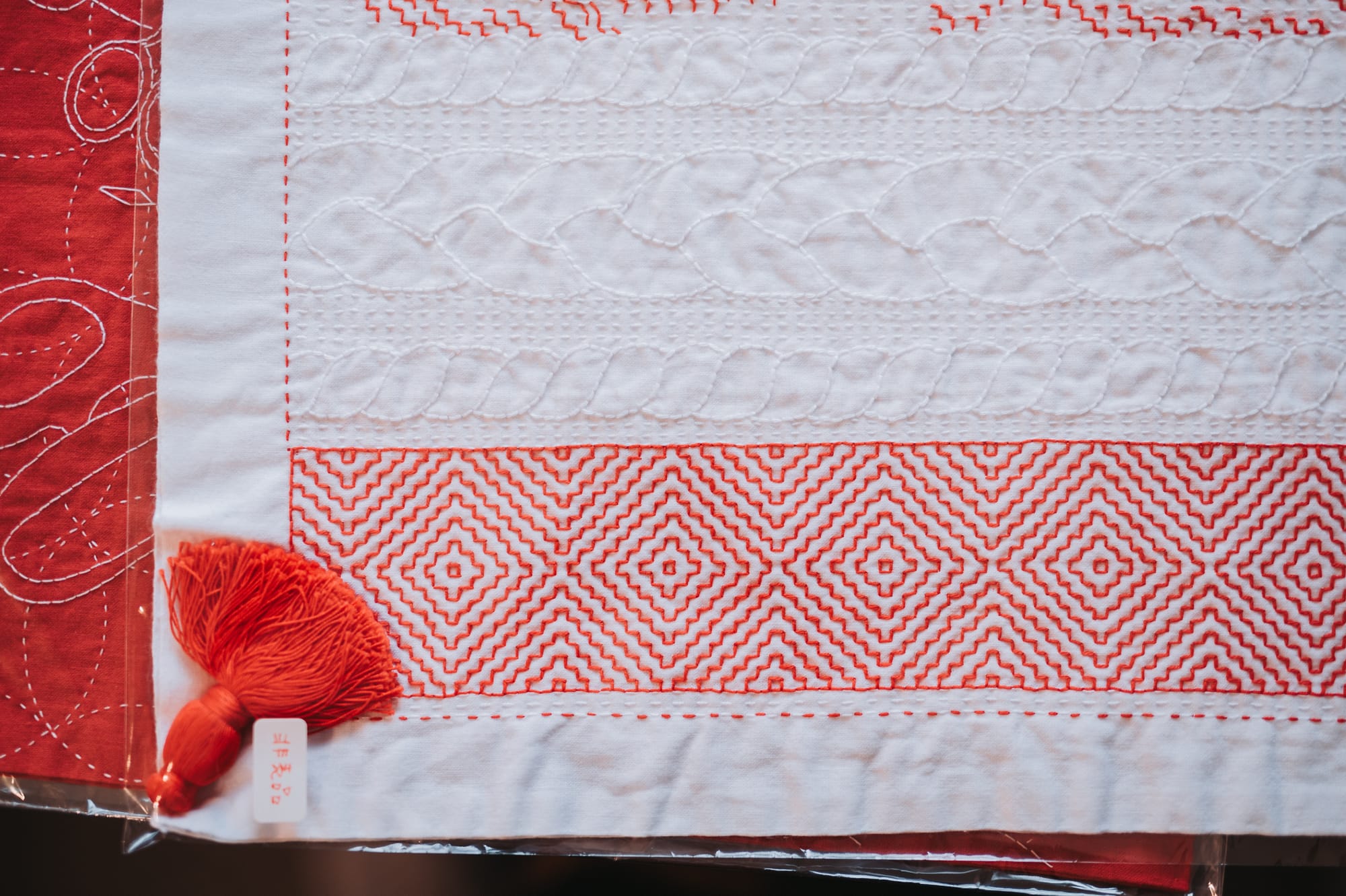 Sashiko design drafted and stitched by Chiebaa in red and white thread on white fabric