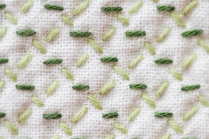 Sashiko Pattern Hitomekagome in two shades of green on white fabric