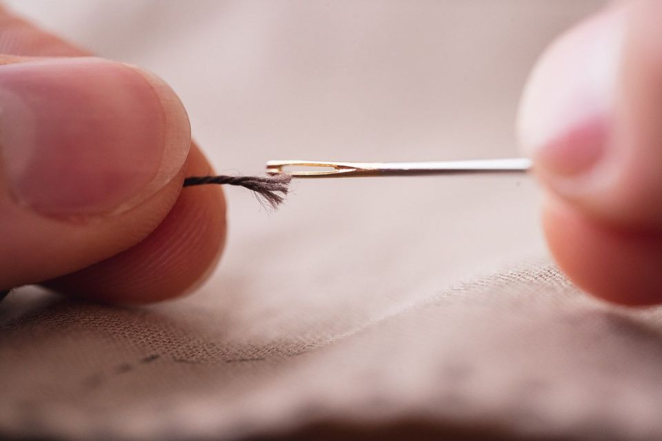 Needle and frayed thread that is wider than the needle's eye.