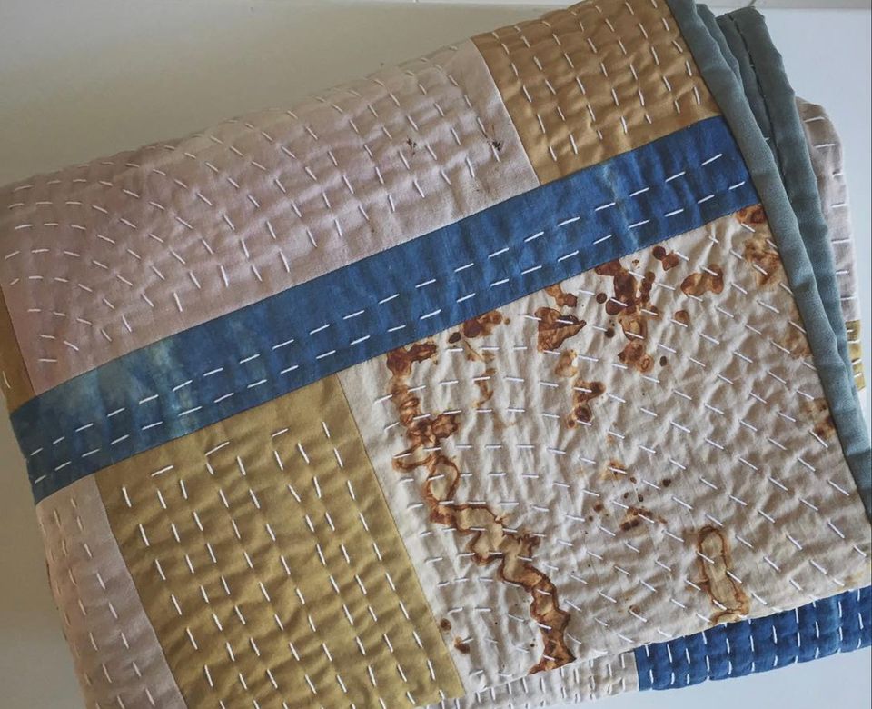 Beautiful quilt in earthy colors with a white running stitch